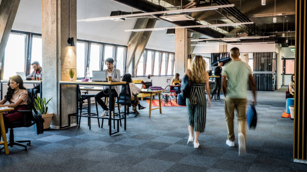 An open office space with stylishly dressed employees working and walking around to emulate celebrity fashion.